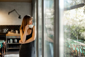 Woman with high-functioning anxiety looking out window in Northern Virginia home