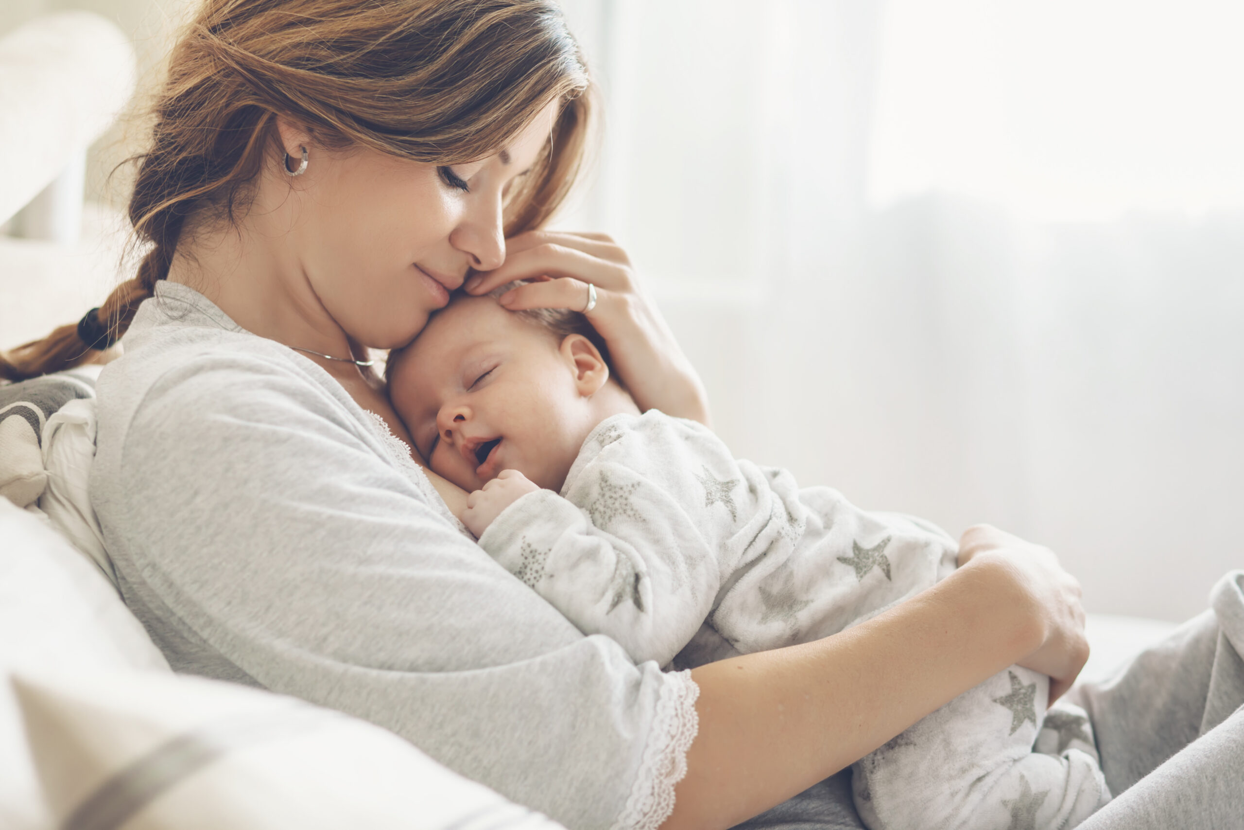 Mother recovering from postpartum depression and anxiety bonding with sleeping baby