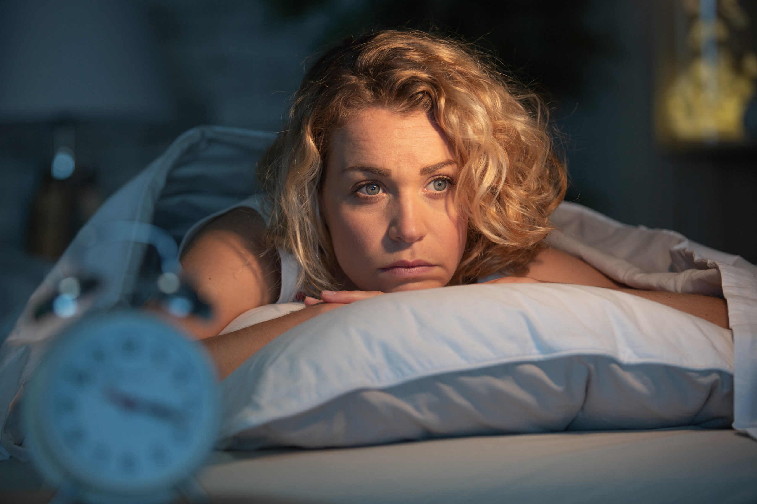 Woman lying awake at night with anxiety-driven insomnia in her Northern Virginia home